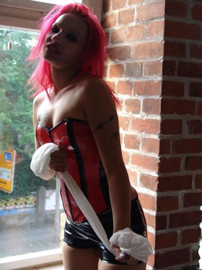 16P Solo girl with pink hair fastens a cleave gag to her mouth in spandex apparel