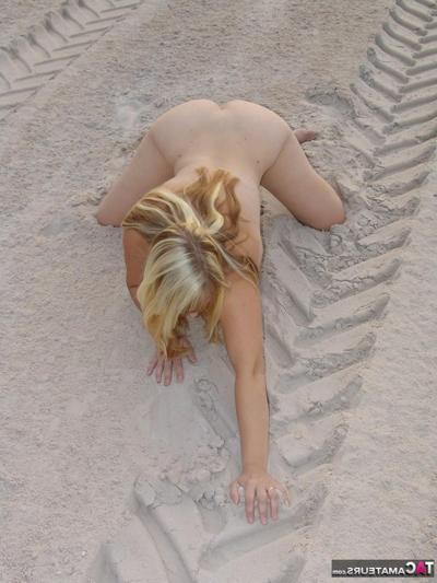 20P Mature blonde Sweet Susi doffs a bikini to pose naked in a sand pit