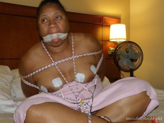 16P Ebony fatty receives electrical shocks while tied up and gagged on a bed