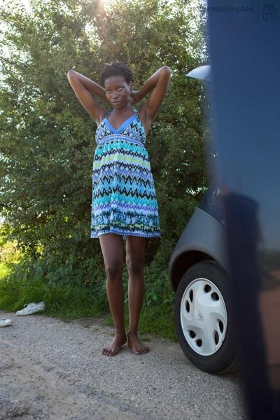16P Naked black female with long legs gets dressed by the side of the rode