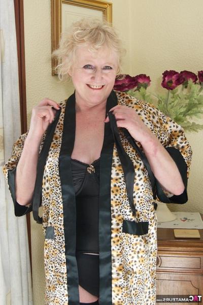 16P Blonde granny admires herself in a mirror while wearing lingerie and nylons