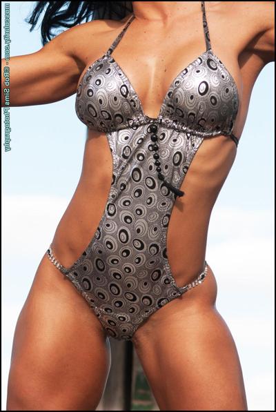 15P Bodybuilder Amy Perkins flexes her muscles in a silver swimsuit and boots