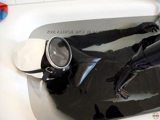 15P Rubber attired couple engage in breath play while submerged in a tub of water