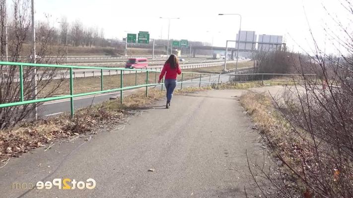 15P Nicolette Noir pauses to take a piss on a paved roadway during the day