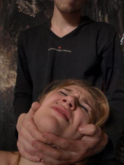 12P Caucasian girl grimaces in pain while being affixed with clothes pegs