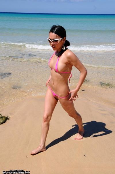 16P Slender brunette reveals her pussy at the beach while in a micro bikini