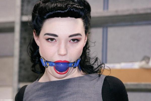 20P Fully clothed gagged babe Lilly struggles to be free of her rope bondage