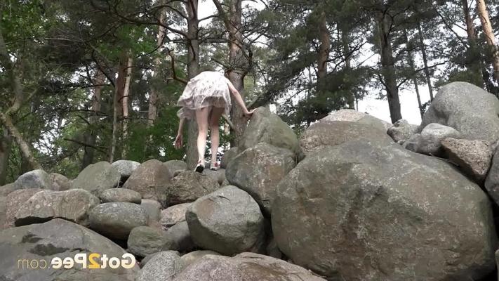 15P Skinny girl Jeanna shows her bush while taking a piss atop some boulders