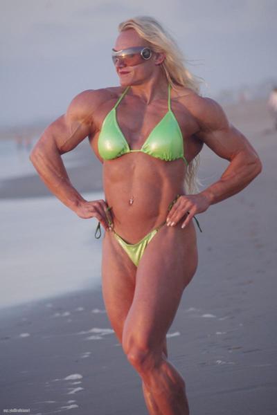15P Blonde Boybuilder Brigita Brezovac сгибает свои мышцы на пляже в бикини