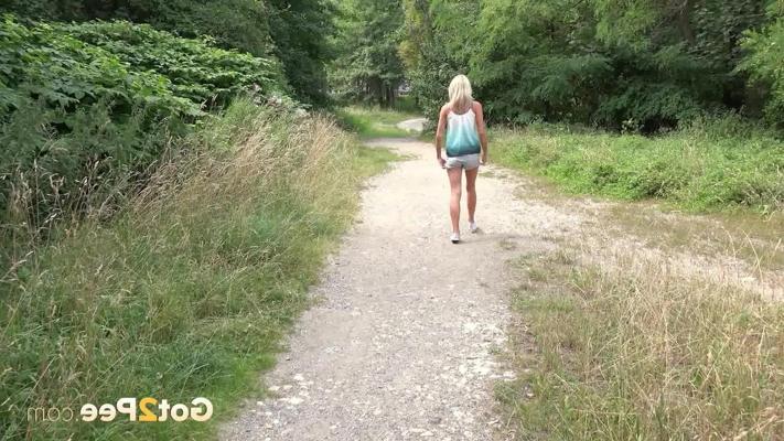 15P Blonde girl Claudia Macc takes a piss on a walking path during the day