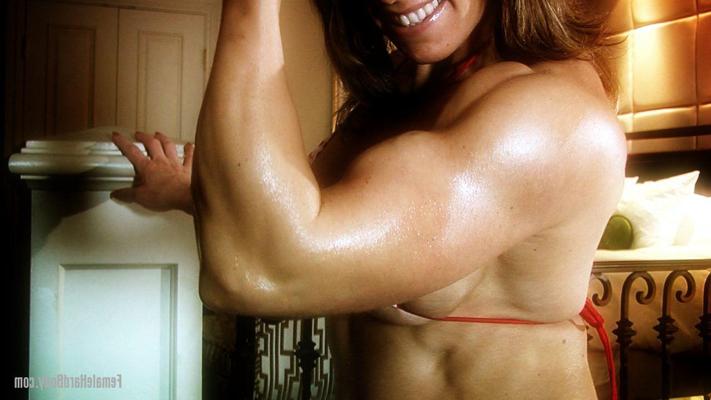 15P Female bodybuilder Roseanne flexes her muscles in a string bikini