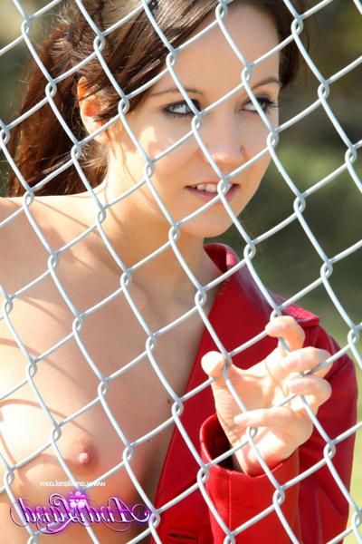 15P Teen amateur Andi Land shows her small tits & pussy against a chain-link fence