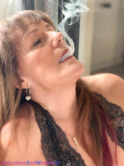 15P Badass mature woman poses in her lingerie while smoking a cigarette