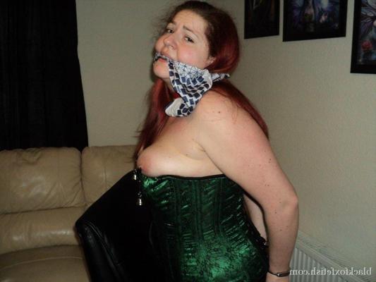 16P Chubby redhead sports a cleave gag with her wrists handcuffed behind her back