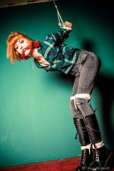 16P Redheaded girl is gagged and restrained in her clothes and black leather boots
