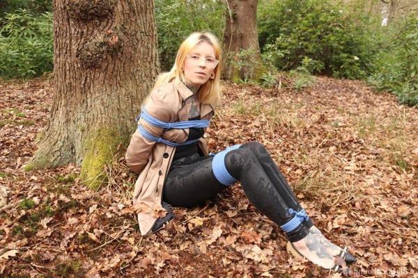 16P Glasses wearing woman in tied with ropes to a treed in woods with clothes on