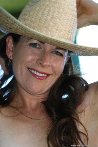 20P Mature cowgirl Andie shows her small tits & her hairy pussy outdoors