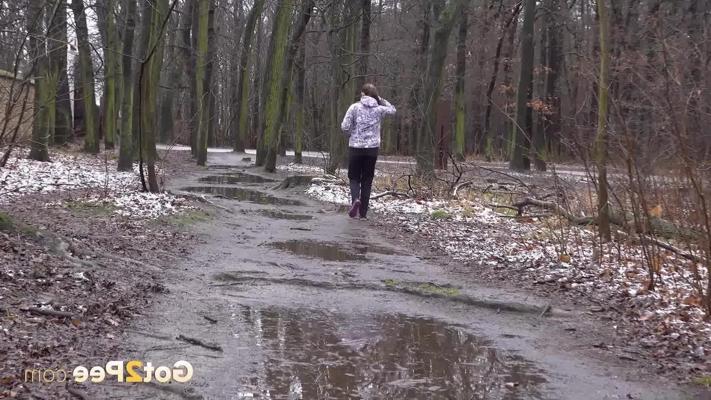 15P Caucasian woman pulls down her pants to pee on a puddle strewn roadway