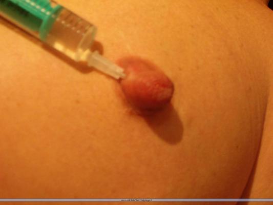 16P Naked blonde has her nipples pierced with a hypodermic needle