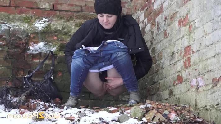 15P White girl Katya takes a pee on snow-covered ground against a brick building